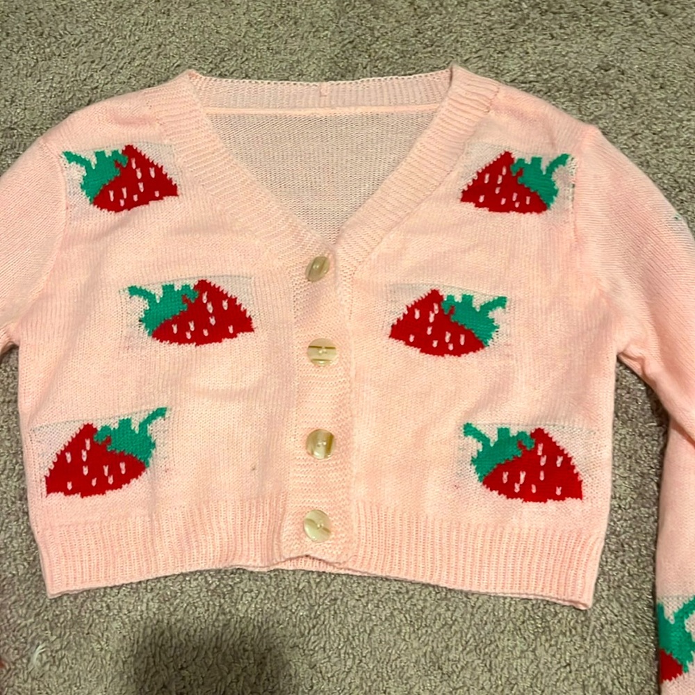Light pink sweater with strawberry’s on it